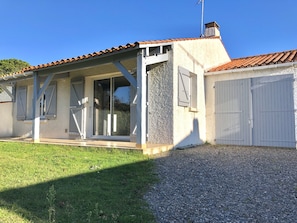 Une maison avec un toit en tuiles, une véranda et un garage.