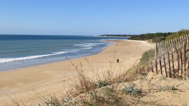 A beach with a wooden fence, sandy shore, and ocean waves. - LocaJard House "Les Sternes" 400m from sandy beaches, 70m², 3 bedrooms (Saint-Vincent-sur-Jard)