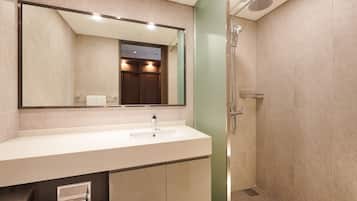 A modern bathroom with a large mirror, a sink, and a shower.
