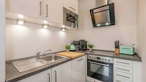 A modern kitchen with a built-in oven, microwave, and coffee maker.