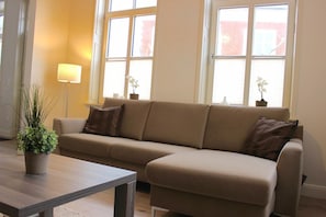 Un salon avec un canapé, une table basse et une plante en pot.