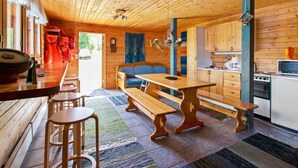 A wooden cabin with a kitchen, dining area, and a sofa. - Heinäsorsa by Interhome (Joutsa)