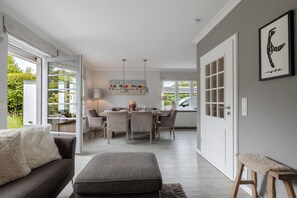 Un intérieur moderne comprenant un coin repas, un canapé et un banc.