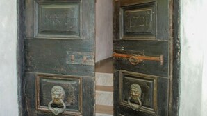 Dos puertas de madera oscura con aldabillas metálicas y tiradores de latón, una con la etiqueta "MAP" y la otra con la etiqueta "L21".