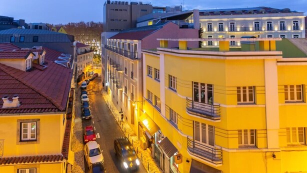 A street view of a city with buildings, cars, and a restaurant sign. - Cozy Lisbon Stay - 2 Min Walk from Av. Liberdade by Lisbeyond (Lisboa)