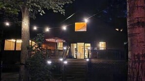 A building with a porch and string lights.