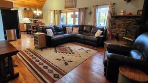 A cozy living room with a sectional sofa, a fireplace, and a dining area.