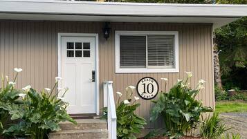 A small building with a white door, a window with blinds, and a sign indicating it is a '10 Cabin'.