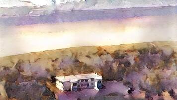 A single-story building with a flat roof, surrounded by a hilly landscape.