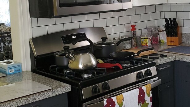 A kitchen with white cabinets, a stainless steel microwave, a gas stove, and a stainless steel oven. - Luxry Seaview House by the Ocean (Lucea)