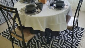 A dining table set with multiple glasses, plates, and a jug, surrounded by chairs with a geometric pattern. - Luxry Seaview House by the Ocean (Lucea)