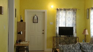 A living room with a sofa, a television, and a small table with a lamp. - Luxry Seaview House by the Ocean (Lucea)