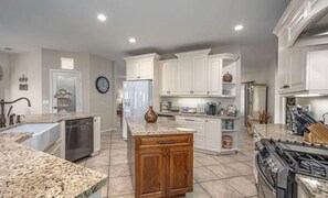 Enjoy cooking in this well-equipped kitchen with a central island, dishwasher, refrigerator, and stove.
