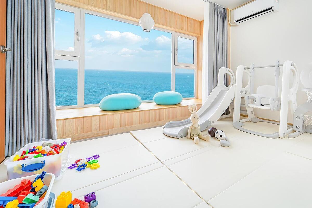 Ein kindgerechtes Zimmer mit Meerblick, inklusive Rutsche, kleiner Basketballkörbe und Spielzeugkisten.
