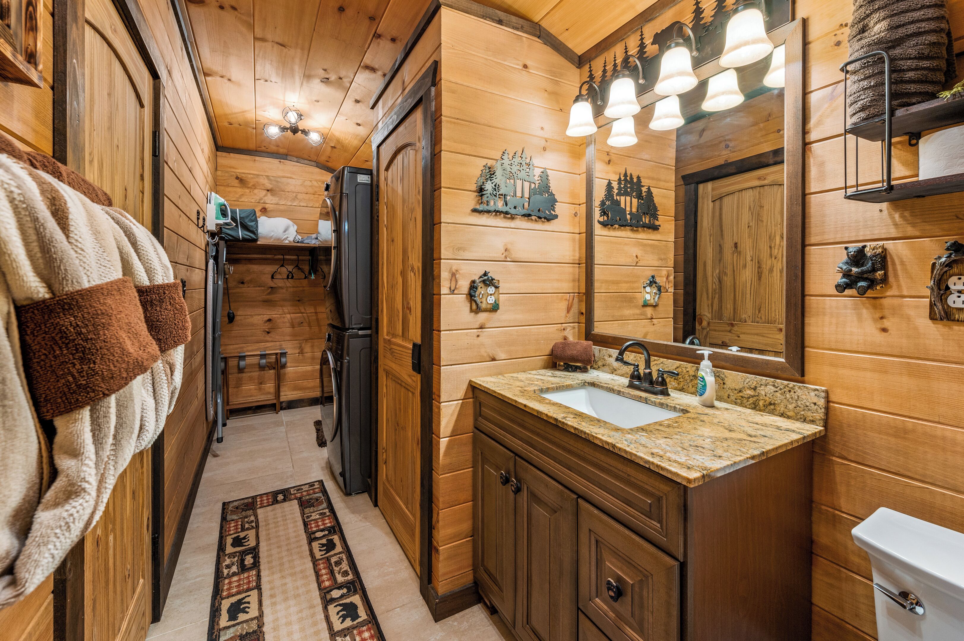 Ein Badezimmer einer Holzhütte mit Waschbecken, Toilette und Spiegel.