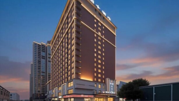 A multi-story hotel with a modern design, featuring a prominent sign at the top.