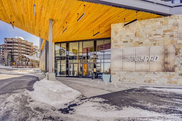 Un bâtiment moderne doté d’une façade en pierre et d’un auvent en bois.
