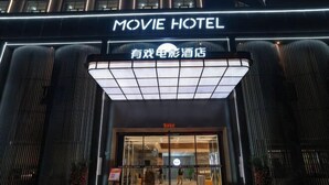 A building with a sign that reads "MOVIE HOTEL" and another sign in a different language. - Movie Hotel (Guangzhou Pazhou Exhibition Center Store) (Guangzhou)