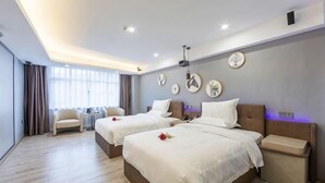 A hotel room with two beds, a sofa, a small table, and a view of the outdoors. - Movie Hotel (Guangzhou Pazhou Exhibition Center Store) (Guangzhou)