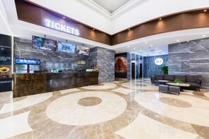 A hotel lobby with a reception desk, a seating area, and a large marble floor. - Movie Hotel (Guangzhou Pazhou Exhibition Center Store) (Guangzhou)