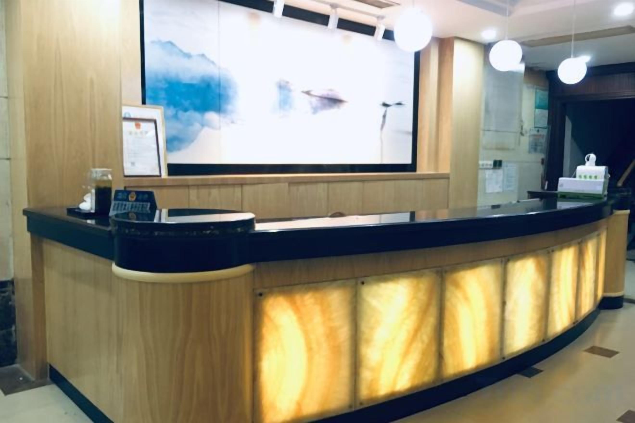A reception desk with a digital screen, a coffee machine, and a framed picture.