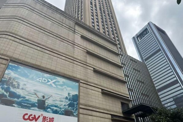 Un edificio alto con un gran anuncio que promociona 4DX.
