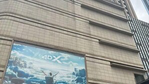 La façana d'un edifici amb un gran cartell publicitari de 4DX.
