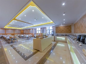 A spacious hotel dining area with multiple tables and chairs, a central counter, and a buffet setup. - Vienna International Hotel (Wuhan)