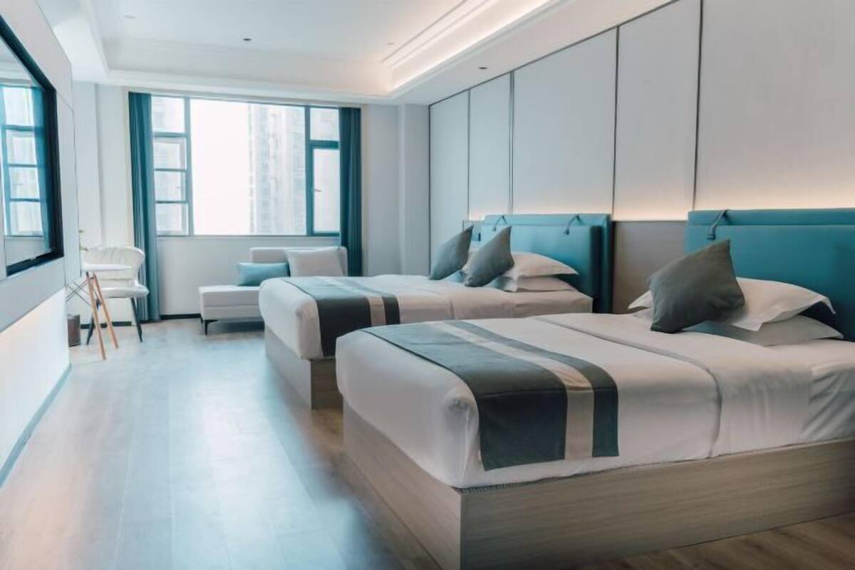Een moderne hotelkamer met twee bedden, een bureau en een stoel.