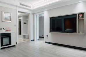 Une chambre d’hôtel moderne dotée d’une grande fenêtre, d’un téléviseur intégré et d’un mini-bar.