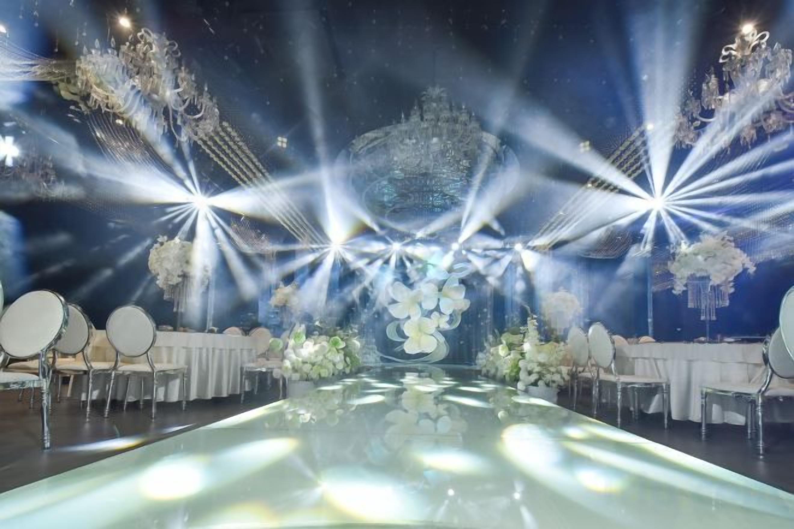 Un espacio para eventos formales con mesas, sillas y arreglos florales.