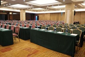 A conference room with rows of tables and chairs, equipped with water bottles and nameplates. - Jianning Hotel (Jianning)