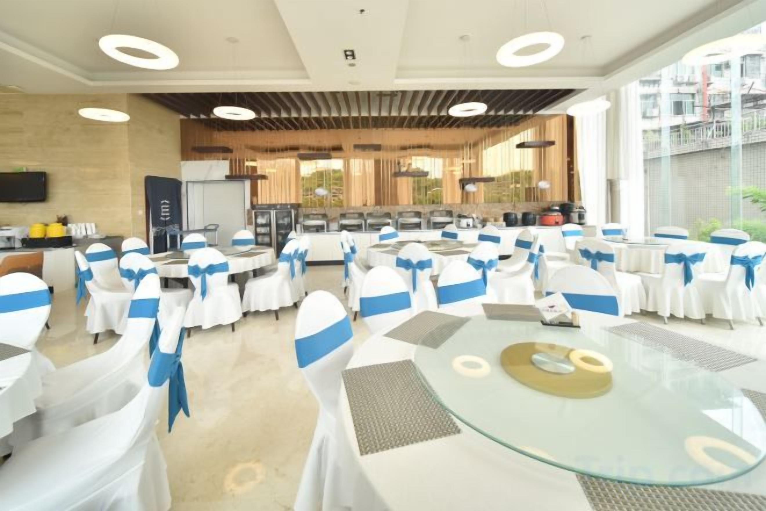 Un salón de banquetes con mesas redondas, sillas y una zona de bufé.