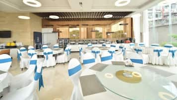 Un salón de banquetes con mesas redondas, sillas y una zona de bufé.