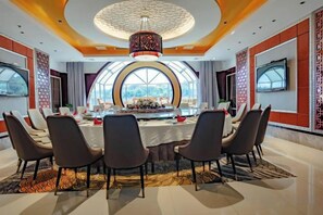Une salle de conférence équipée d’une table ronde, de chaises et d’un grand écran.