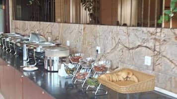 Montaje de bufé con diferentes recipientes de comida y una cesta de pan.