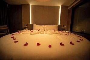 A hotel room with a neatly made bed, a large window, and a wall-mounted lamp. - Jianning Hotel (Jianning)