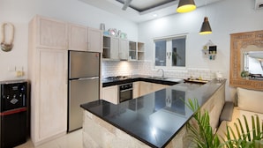 A modern kitchen with a central island, stainless steel appliances, and light wood cabinets. - OriVista Charming Villa Shree Canggu 2 mins to beach (Canggu)