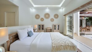 A bedroom with a large bed, bedside tables, a ceiling light, and a view to an outdoor area. - OriVista Charming Villa Shree Canggu 2 mins to beach (Canggu)
