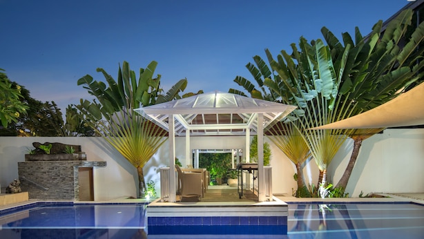 A swimming pool with a covered seating area, surrounded by tropical plants. - OriVista Charming Villa Shree Canggu 2 mins to beach (Canggu)
