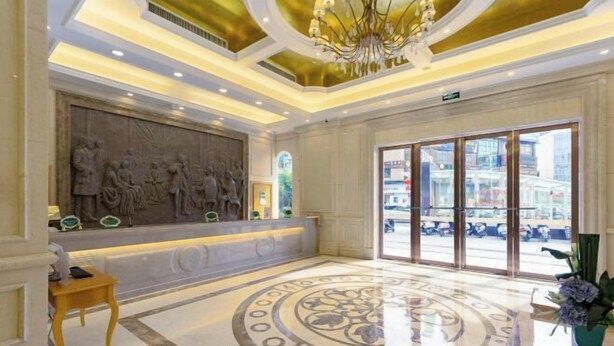 A lobby with a reception desk, a large chandelier, and a patterned floor. - Vienna Hotel (Lingshan Liufengshan Pedestrian Street) (Lingshan)