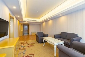 A modern living room with a sofa set, a coffee table, and a flat-screen TV. - Vienna Hotel (Lingshan Liufengshan Pedestrian Street) (Lingshan)