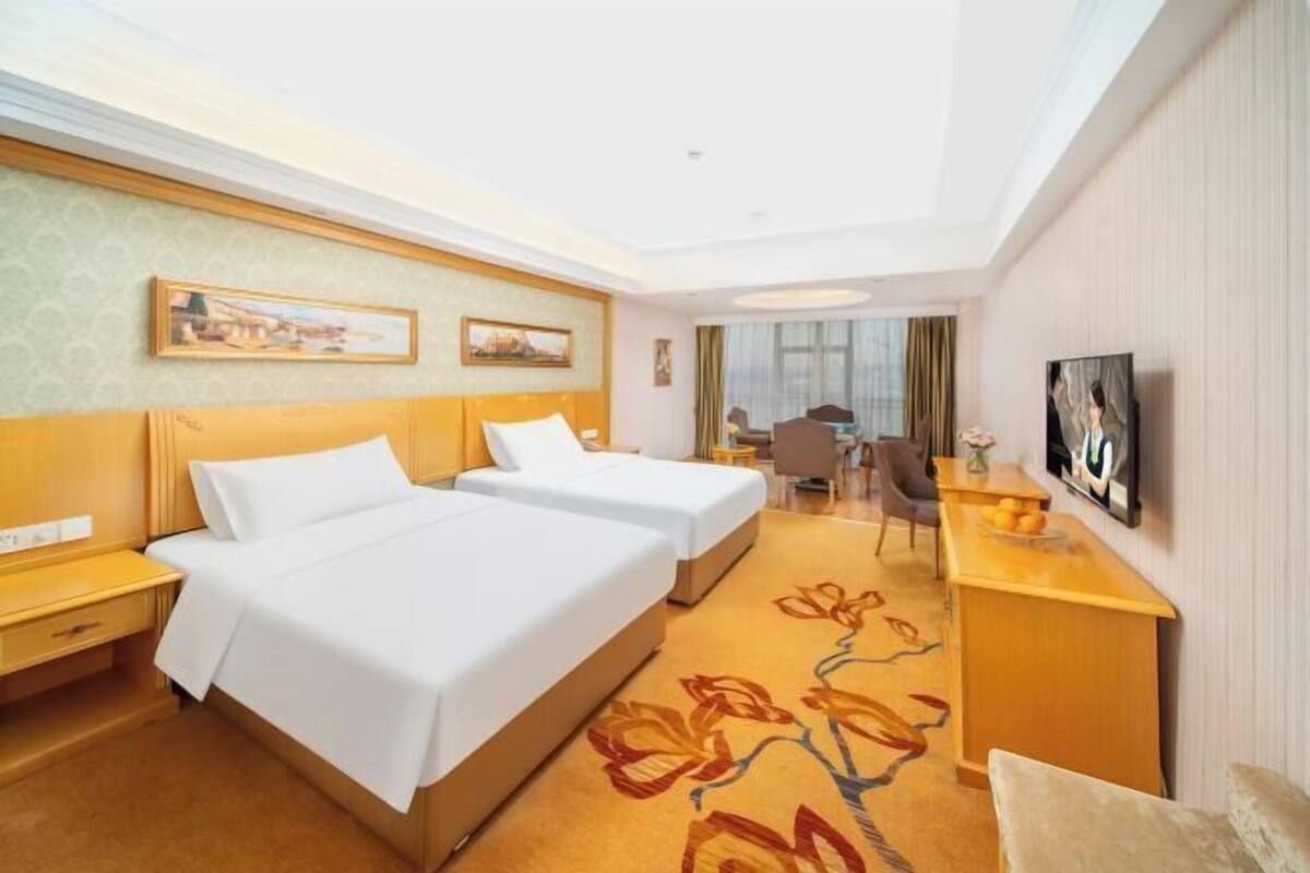 Une chambre d’hôtel équipée d’un lit, d’un bureau, d’une chaise et d’un téléviseur.