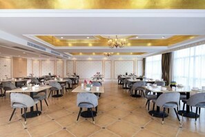 A spacious dining area with multiple tables and chairs, a chandelier, and a tiled floor. - Vienna Hotel (Lingshan Liufengshan Pedestrian Street) (Lingshan)