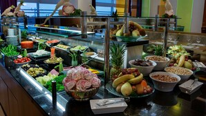 A buffet with various food items and a decorative bird statue.