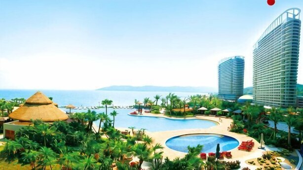 A resort with a large pool, palm trees, and modern buildings. - Huidong Biguiyuan Shili Silver Beach Ocean Star Scenic Resort Apartment (Huidong)