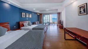 A hotel room with two beds, a wooden bench, a TV, and a balcony with a view. - Huidong Biguiyuan Shili Silver Beach Ocean Star Scenic Resort Apartment (Huidong)