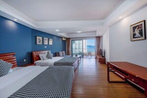 A hotel room with two beds, a wooden bench, a TV, and a balcony with a view. - Huidong Biguiyuan Shili Silver Beach Ocean Star Scenic Resort Apartment (Huidong)