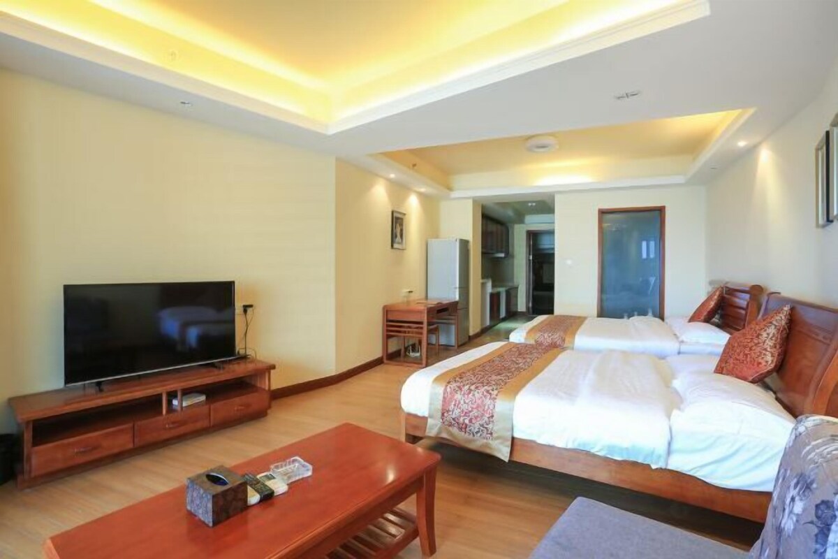 Quarto de hotel com televisão, cama de madeira, secretária e cadeira.