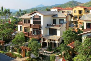 A residential area with multi-story houses, lush greenery, and a mountainous backdrop. - Huidong Biguiyuan Shili Silver Beach Ocean Star Scenic Resort Apartment (Huidong)